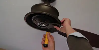 Electrician installing ceiling fan mounting bracket and fixture in Chicago, IL