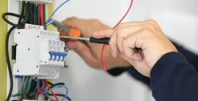 Electrician installing and adjusting circuit breakers in an electrical panel in Chicago, IL