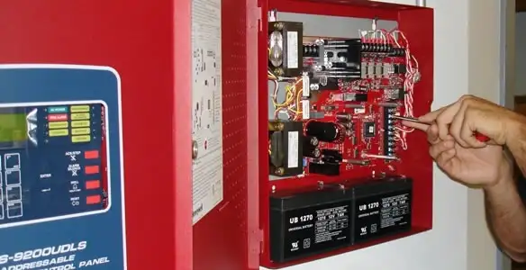 fire alarm installation service showing technician configuring fire alarm control panel in Chicago, IL