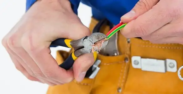 licensed electrician securing electrical wiring with professional tools during service work in Chicago, IL