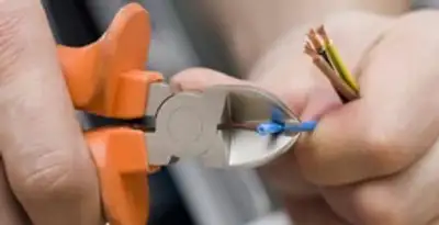 licensed electrician performing precise wire cutting and preparation during electrical service in Chicago, IL