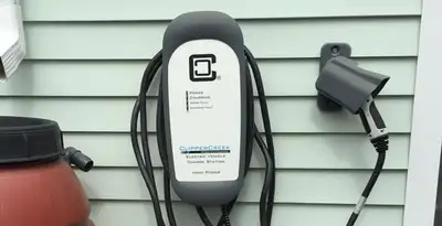 Outdoor electric vehicle charger installation on residential wall in Chicago, IL